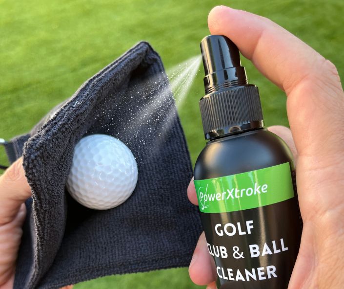 Cleaning a golf ball with microfiber towel – removes dirt for better roll and spin on the green