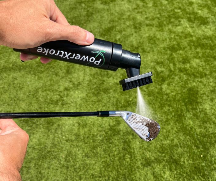 Cleaning a golf club with PowerXtroke bottle and built-in brush – fast and effective on-course maintenance